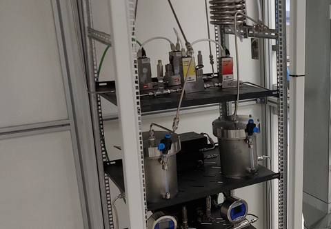 Waterstofopstelling met condensor, reactorvaten en debietmeters in het Saxion-lab.