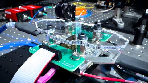 Close-up van de fotonische quantumprocessor-opstelling bij Saxion: chip, PCB en optische koppeling.